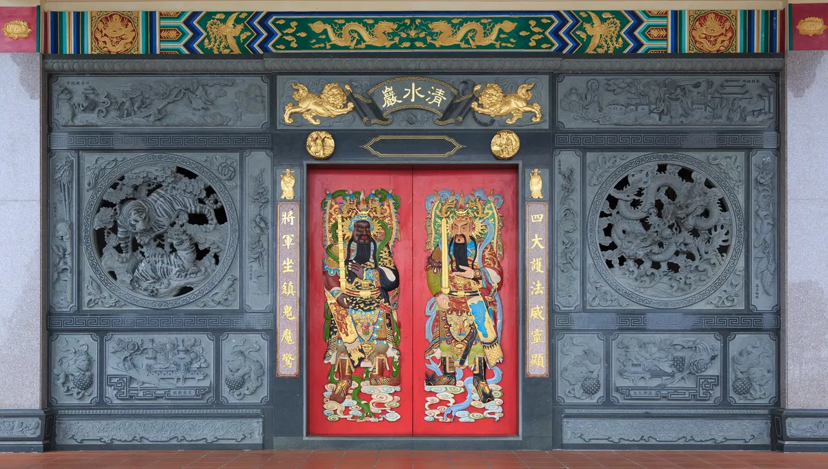 The red doors with painted guardian figures at Chin Swee Caves Temple