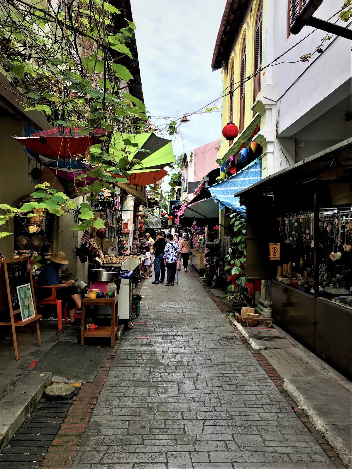 Visitors walking through the narrow Concubine Lane in Ipoh among shops and cafes