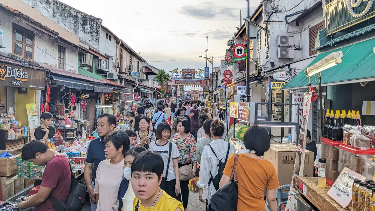 Crowds walking along Jonker Street in Melaka among market stalls