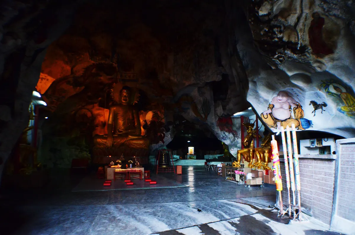 The lit interior of Sam Poh Tong cave temple in Ipoh