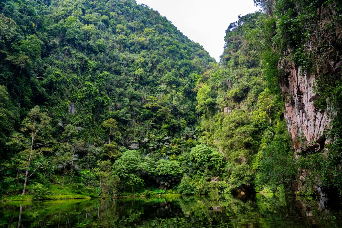 A calm lake below green limestone hills at Mirror Lake in Ipoh